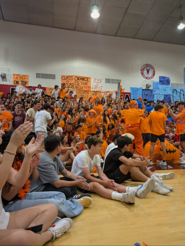 Freshmen spilled out from the stands and had to sit on the floor during the first Class Comp of the year. (Photo by Evelyn Yu)